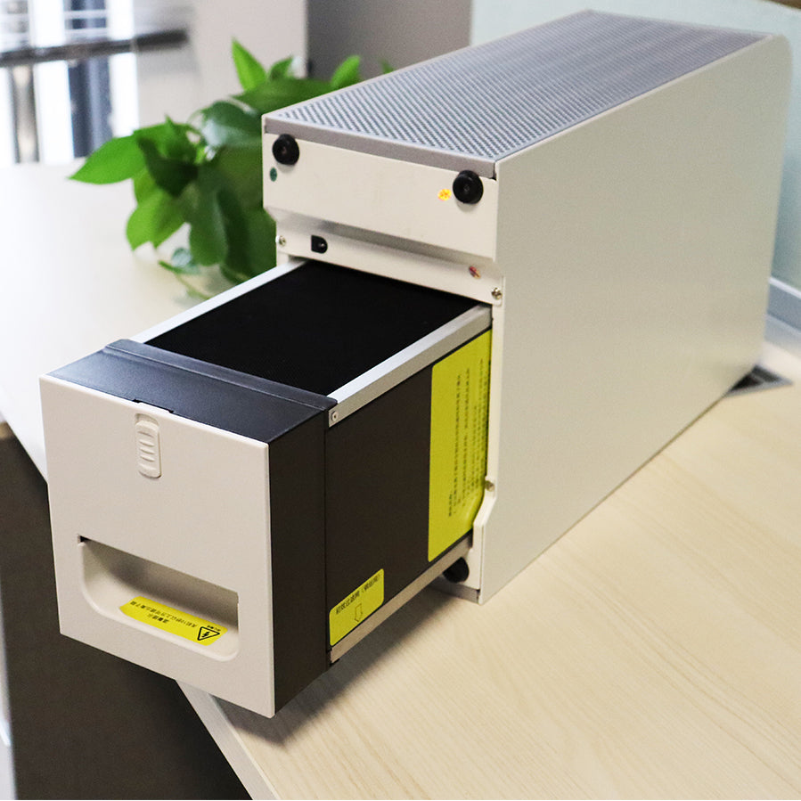 KY-APS-220M washable desktop air purifier positioned horizontally on office conference desk, demonstrating the quick-release slide-out electrostatic precipitator filter cell with yellow operational safety label and ergonomic pull handle for tool-free maintenance.