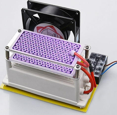    Operational close-up photograph of the KYOG220V10GP ozone generator module during active corona discharge, showcasing the vivid violet plasma glow across dual honeycomb ceramic plates, backed by a high-velocity axial cooling fan and wiring terminal block.
   